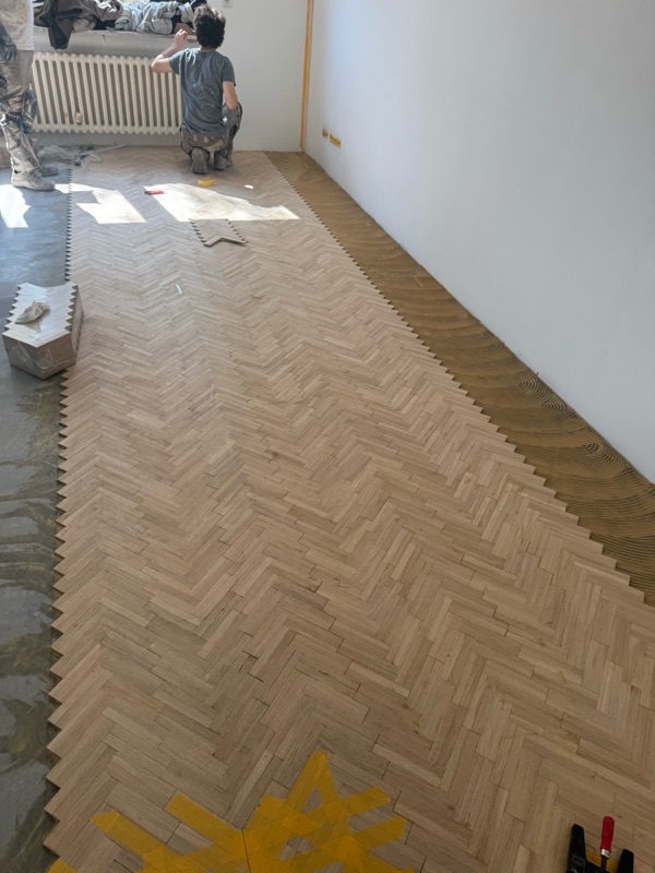 Fast fertig verlegte Fischgrätfläche aus roher Eiche im Wohnraum