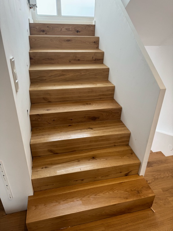 Fertige Treppe mit Massivholzstufen aus Eiche und weißen Wänden